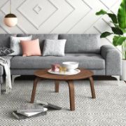 Round coffee table with curved, angled legs reflecting a modern design