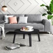 Round coffee table with curved, angled legs reflecting a modern design